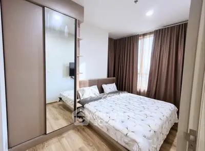 Modern bedroom with large mirrored wardrobe and cozy bed in stylish apartment.