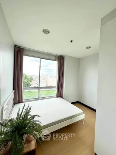 Bright bedroom with large window and scenic view, featuring a cozy bed and stylish decor.