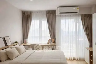 Modern bedroom with large windows, elegant curtains, and a cozy workspace, perfect for relaxation and productivity.