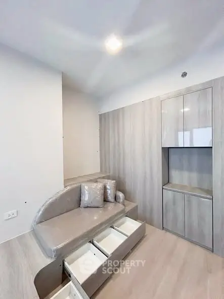Modern minimalist living room with built-in storage and cozy seating area.