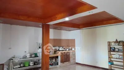 Spacious kitchen area with wooden ceiling and open shelving, perfect for modern living.