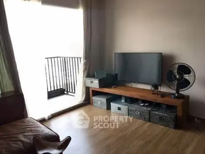 Cozy living room with balcony access, featuring modern TV setup and stylish decor.