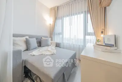 Cozy living room with modern sofa bed and large window with sheer curtains