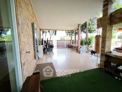 Spacious outdoor patio with tiled flooring and garden view, perfect for relaxation and entertainment.