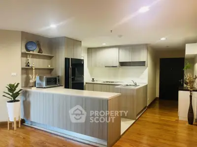 Modern kitchen with sleek cabinetry and hardwood floors in a spacious open layout.