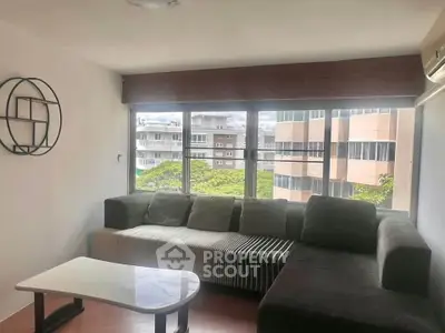 Modern living room with large windows and stylish furniture, offering a bright and airy atmosphere.