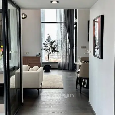 Modern living room with floor-to-ceiling windows and elegant decor in urban apartment.