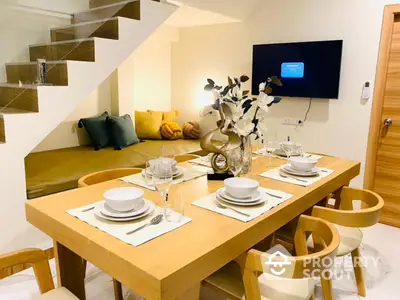 Modern dining area with stylish wooden table and cozy seating under staircase