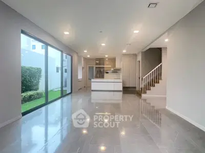 Spacious modern living room with open kitchen and garden view