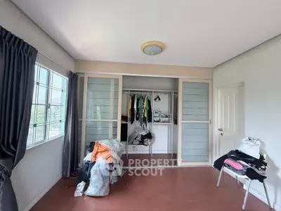 Spacious bedroom with large window and built-in closet, perfect for natural light lovers.