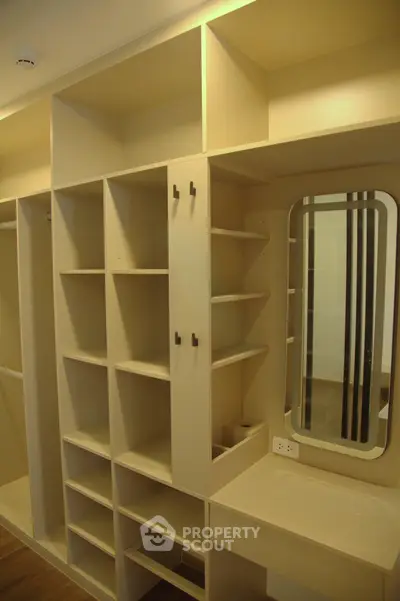 Spacious walk-in closet with built-in shelves and vanity mirror