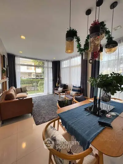 Spacious living room with modern decor and large windows offering abundant natural light.