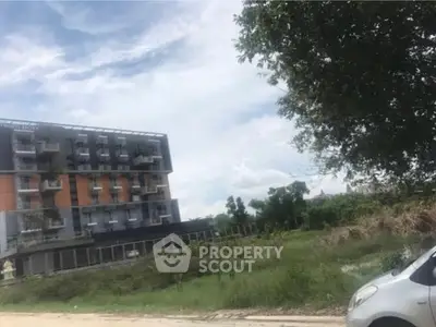 Modern apartment building with lush greenery and clear sky