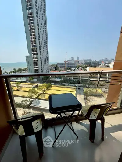 Stunning balcony view with modern seating overlooking cityscape and ocean