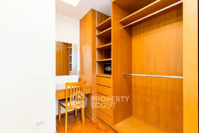 Spacious walk-in closet with wooden shelves and dressing table