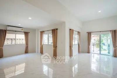 Spacious bright living room with large windows and elegant curtains in modern home