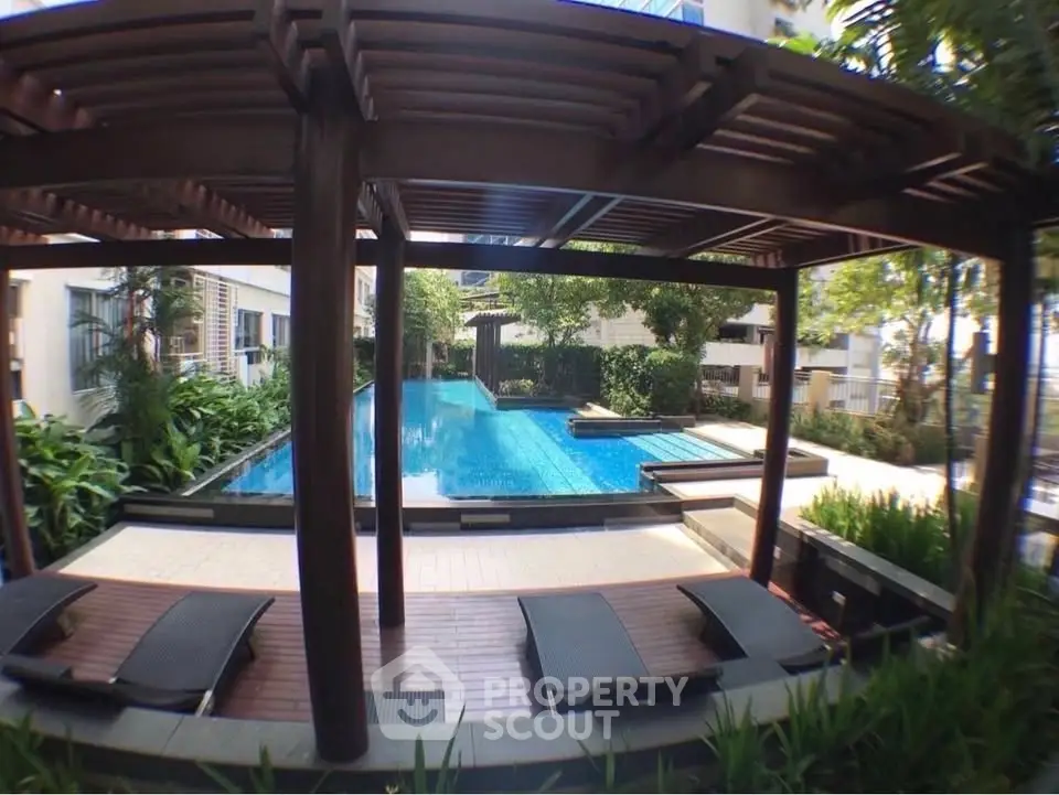 Luxurious outdoor pool area with modern pergola and lush greenery, perfect for relaxation and leisure.