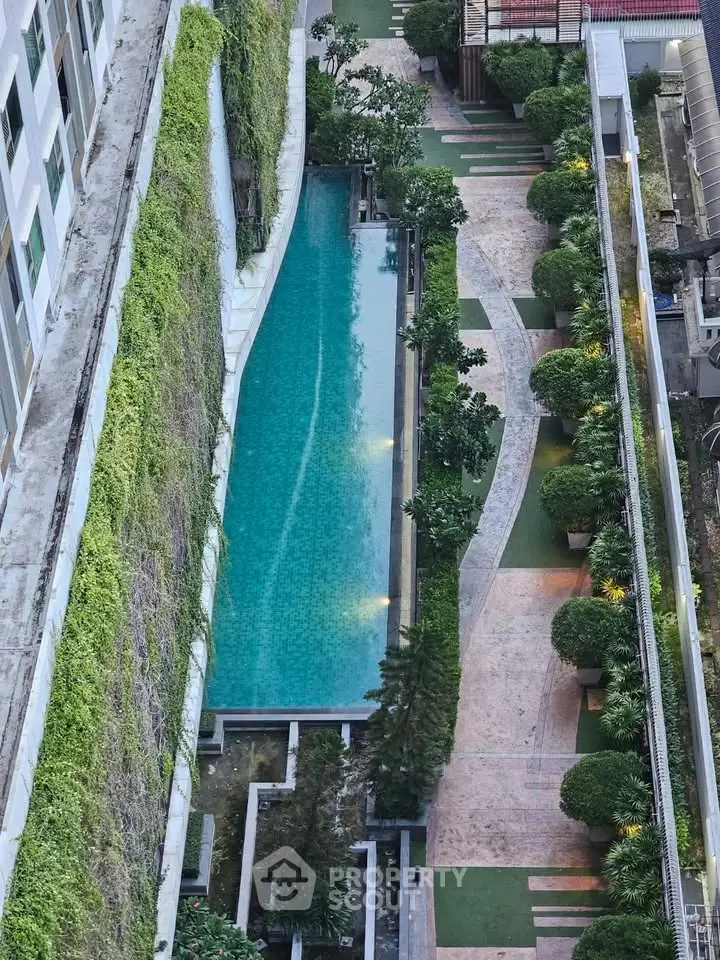 Stunning aerial view of a luxurious residential pool surrounded by lush greenery and modern architecture.