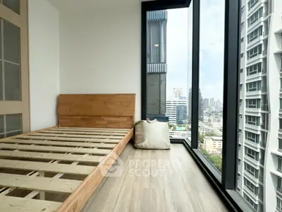 Modern bedroom with large windows offering stunning city views in a high-rise building.