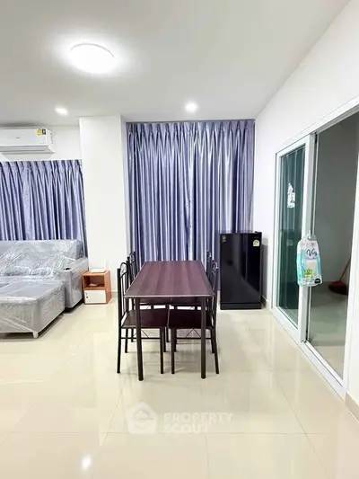 Modern living room with dining area and large windows in a stylish apartment.