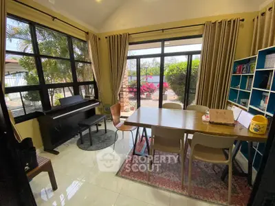 Charming study room with large windows and garden view, perfect for work or relaxation.