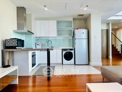 Modern kitchen with sleek appliances and wooden flooring in a stylish open-plan layout.