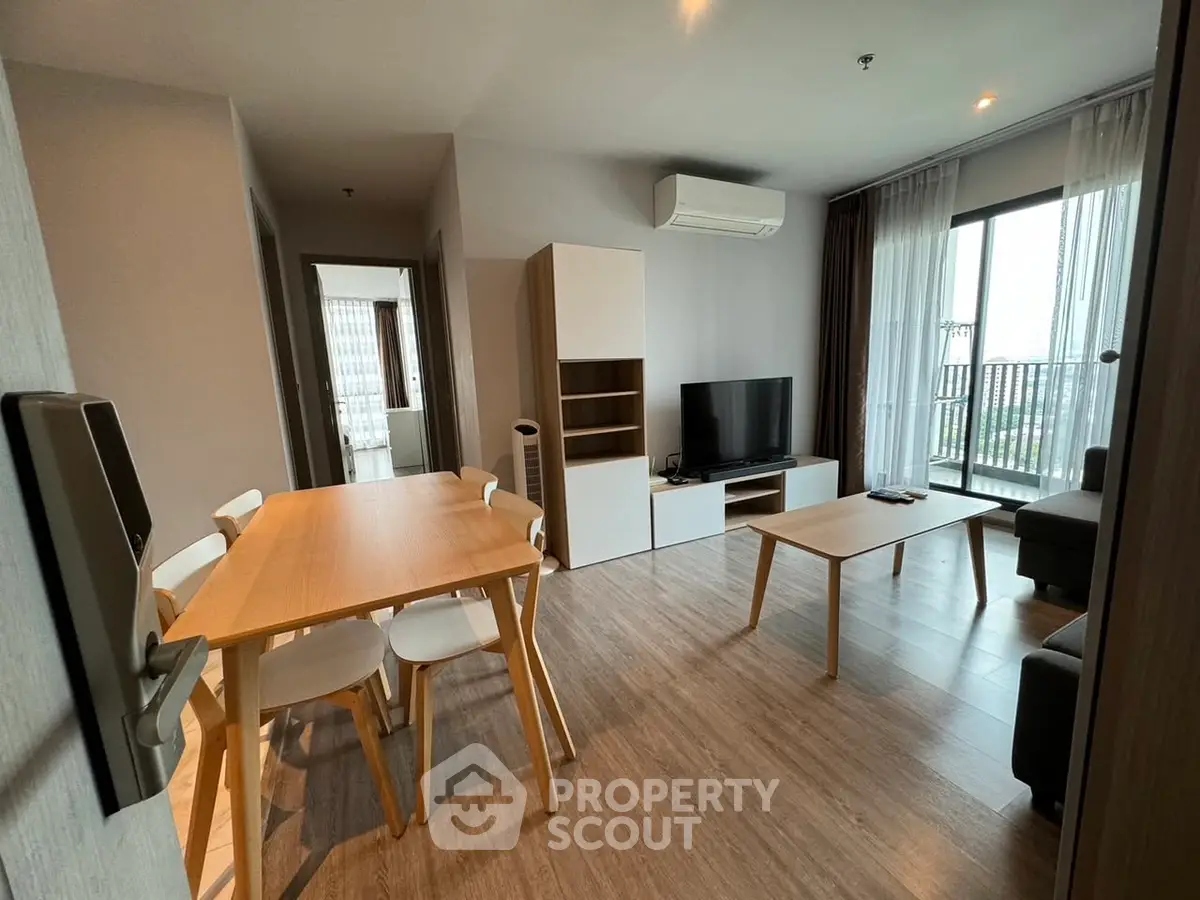 Modern living room with dining area and balcony view in a stylish apartment.