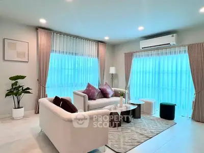Elegant living room with modern decor, featuring plush sofas, stylish curtains, and ambient lighting.