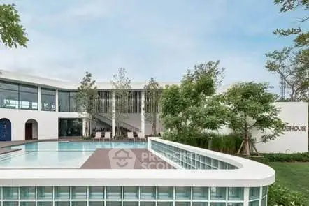 Modern luxury building with pool and lush greenery, perfect for upscale living.