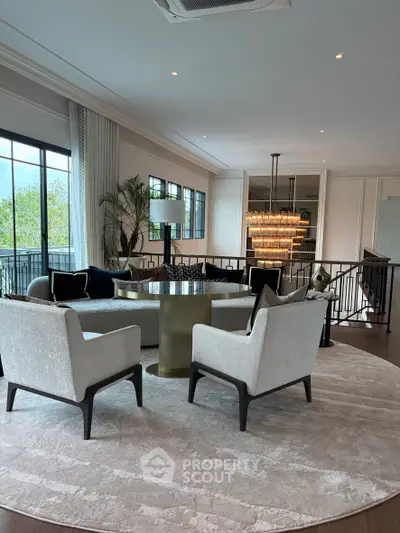Luxurious living room with elegant furniture and stunning chandelier, perfect for sophisticated gatherings.