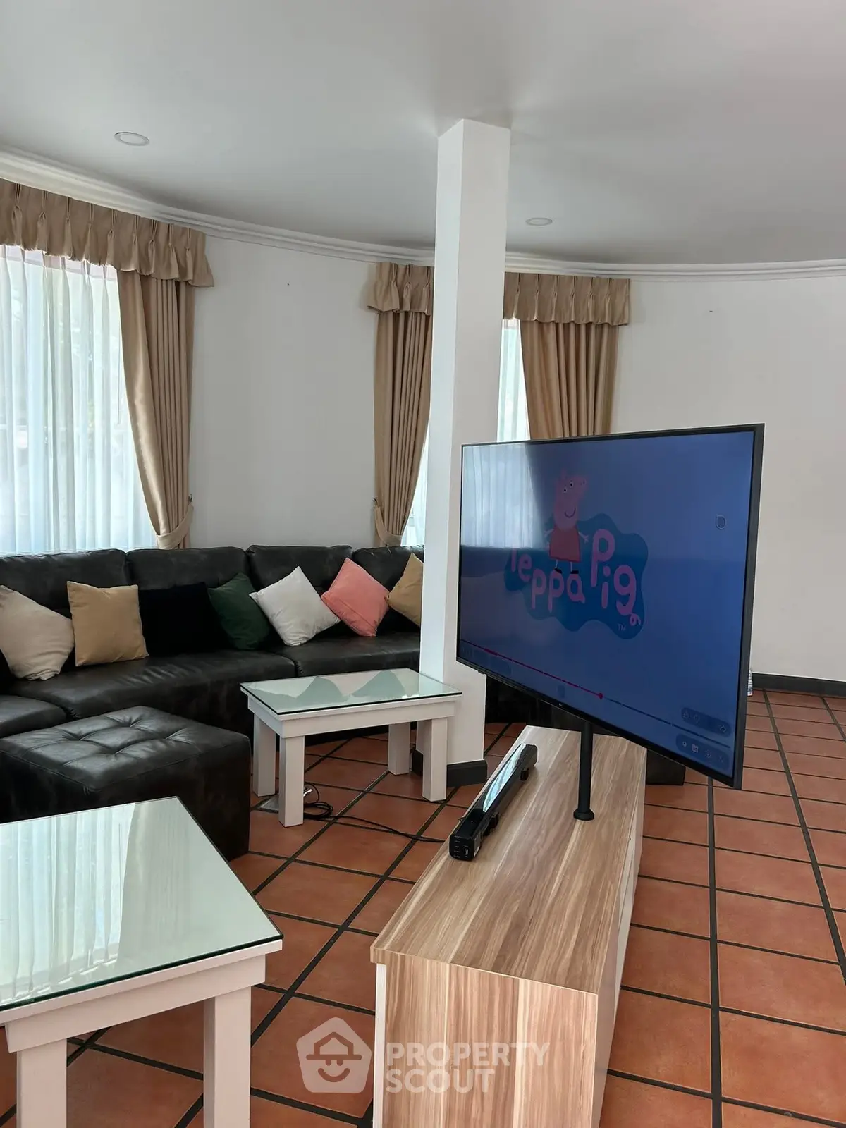 Spacious living room with modern TV setup and cozy sectional sofa.