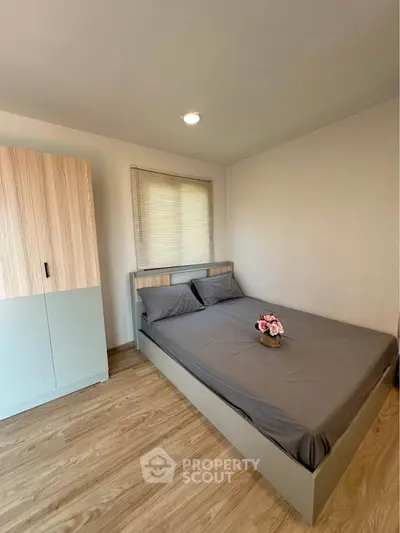 Modern bedroom with wooden flooring and stylish furniture