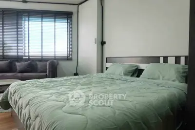 Cozy bedroom with modern decor and large window for natural light.