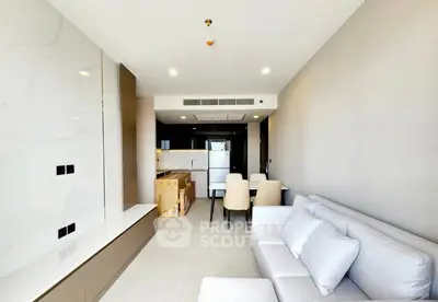 Modern living room with open kitchen, featuring sleek design and neutral tones for a contemporary feel.