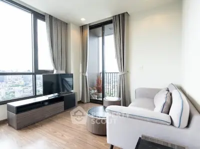 Modern living room with large windows and city view, featuring stylish furniture and elegant decor.