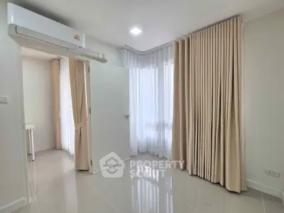 Bright and airy room with large windows and elegant curtains, perfect for a cozy living space.