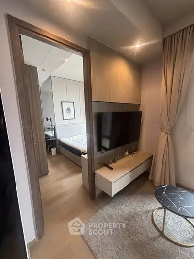 Modern apartment interior with stylish living room and glimpse of cozy bedroom.