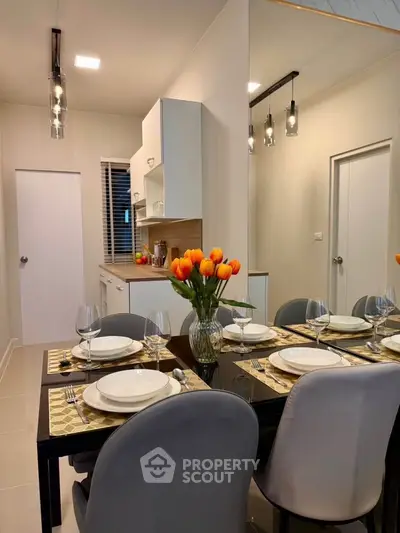 Modern dining area with elegant table setting and kitchen view