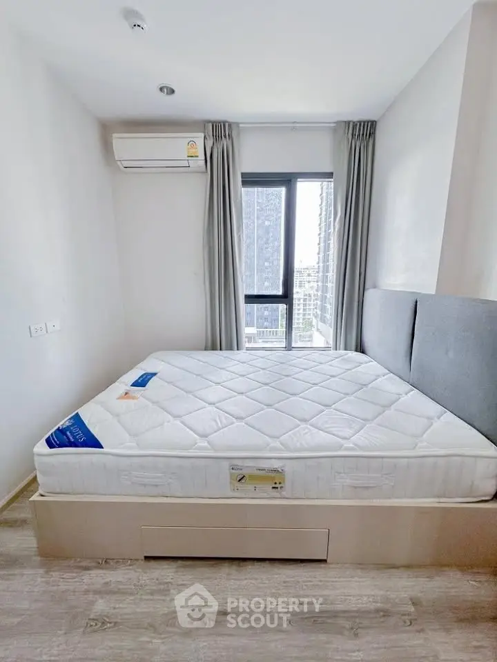 Modern bedroom with large window and air conditioning in a high-rise apartment.