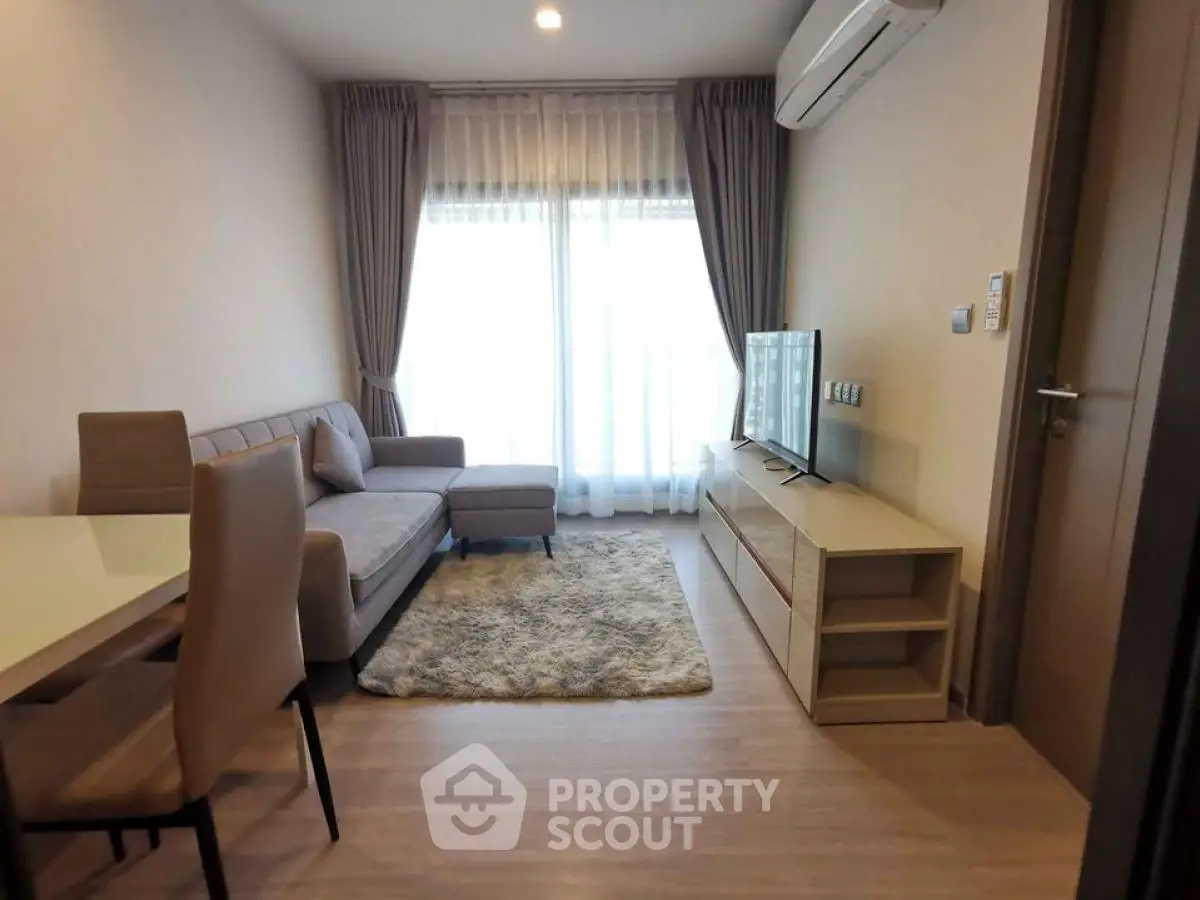 Modern living room with cozy sofa, TV, and dining area in a stylish apartment.