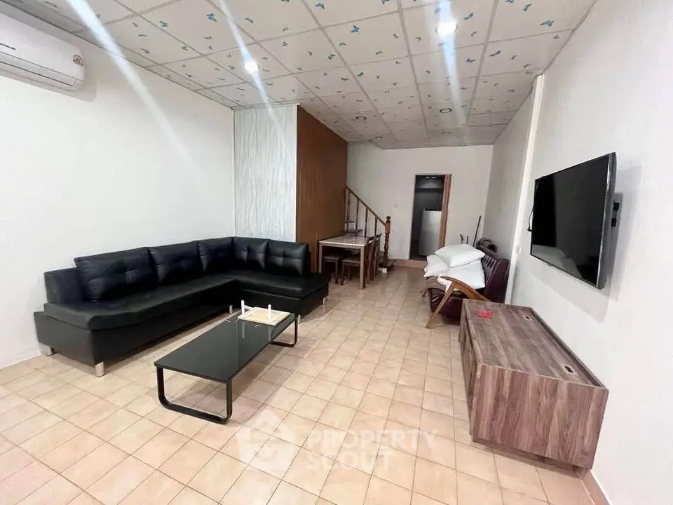 Spacious living room with modern furniture and wall-mounted TV