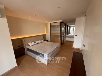 Spacious modern bedroom with elegant lighting and wooden flooring