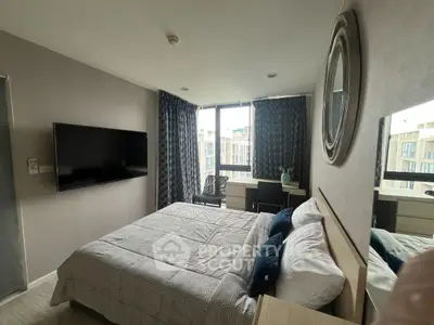 Modern bedroom with large window and stylish decor in urban apartment.