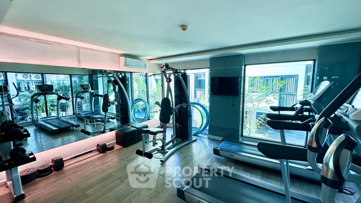 Modern gym with state-of-the-art equipment and large mirrors in a bright fitness room.