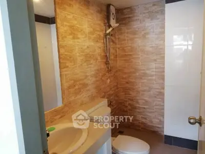 Modern bathroom with stylish tile design and essential fixtures.