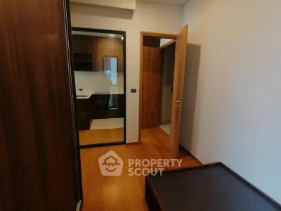 Modern interior with wooden flooring and mirrored wardrobe in a cozy room.