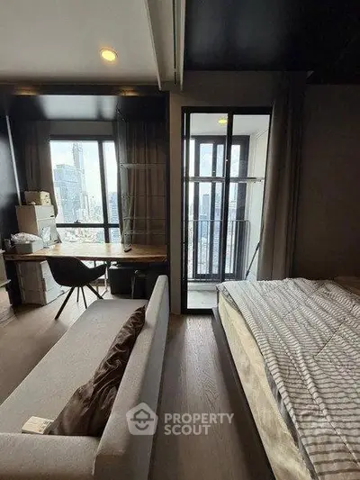 Modern studio apartment with city view, featuring cozy living area and balcony access.