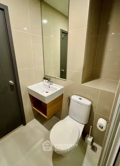 Modern bathroom with sleek fixtures and large mirror in contemporary apartment.
