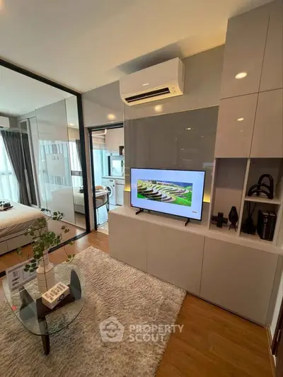 Modern living room with sleek design, featuring a TV, air conditioning, and stylish decor.