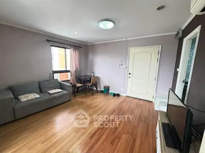 Spacious living room with wooden flooring and modern decor in a cozy apartment.